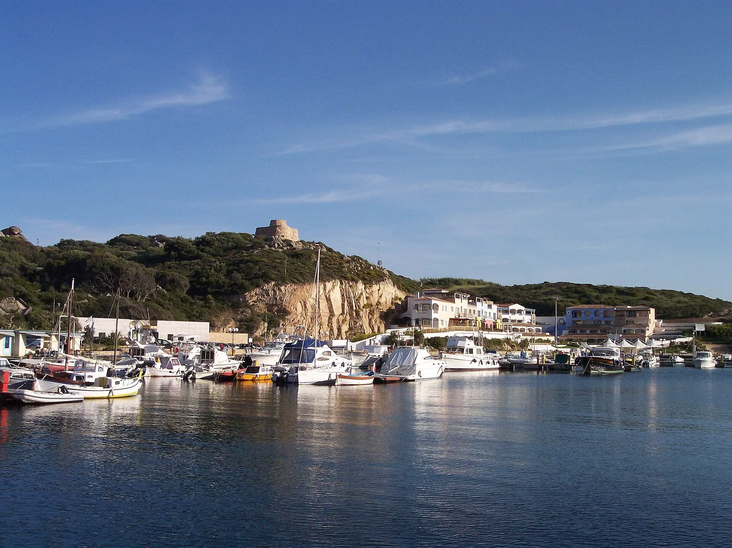 Porto Longosardo con le barche ormeggiate e la torre aragonese sul promontorio